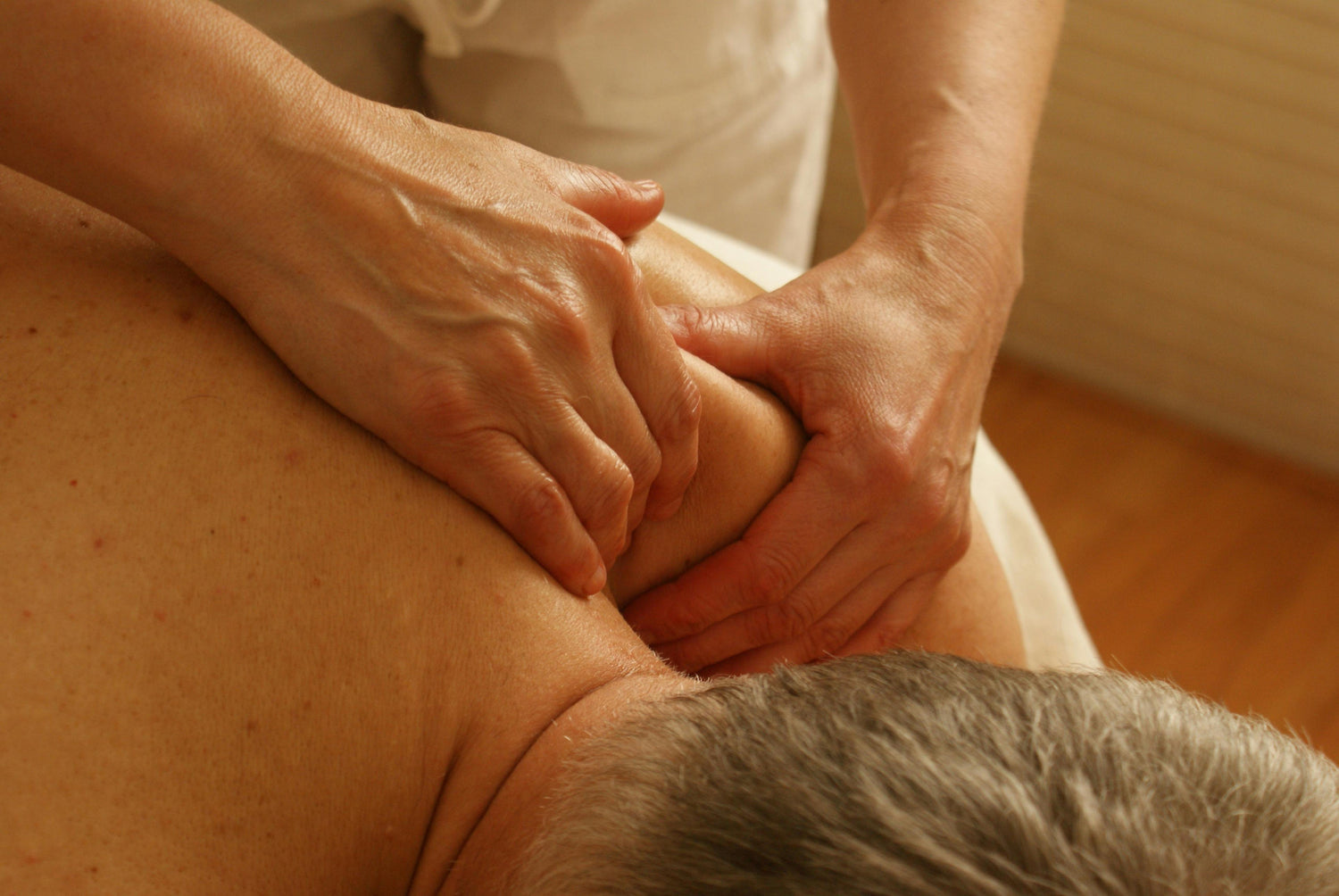 Massaggiatore professionale che esegue un trattamento cervicale per alleviare tensioni muscolari e migliorare il benessere del paziente.